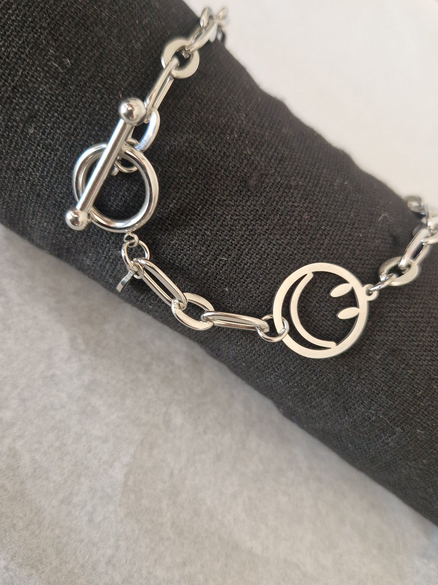 Collier ras-de-cou 'Joie' en acier inoxydable argenté avec pendentif smiley souriant, chaîne moderne et fermoir élégant.